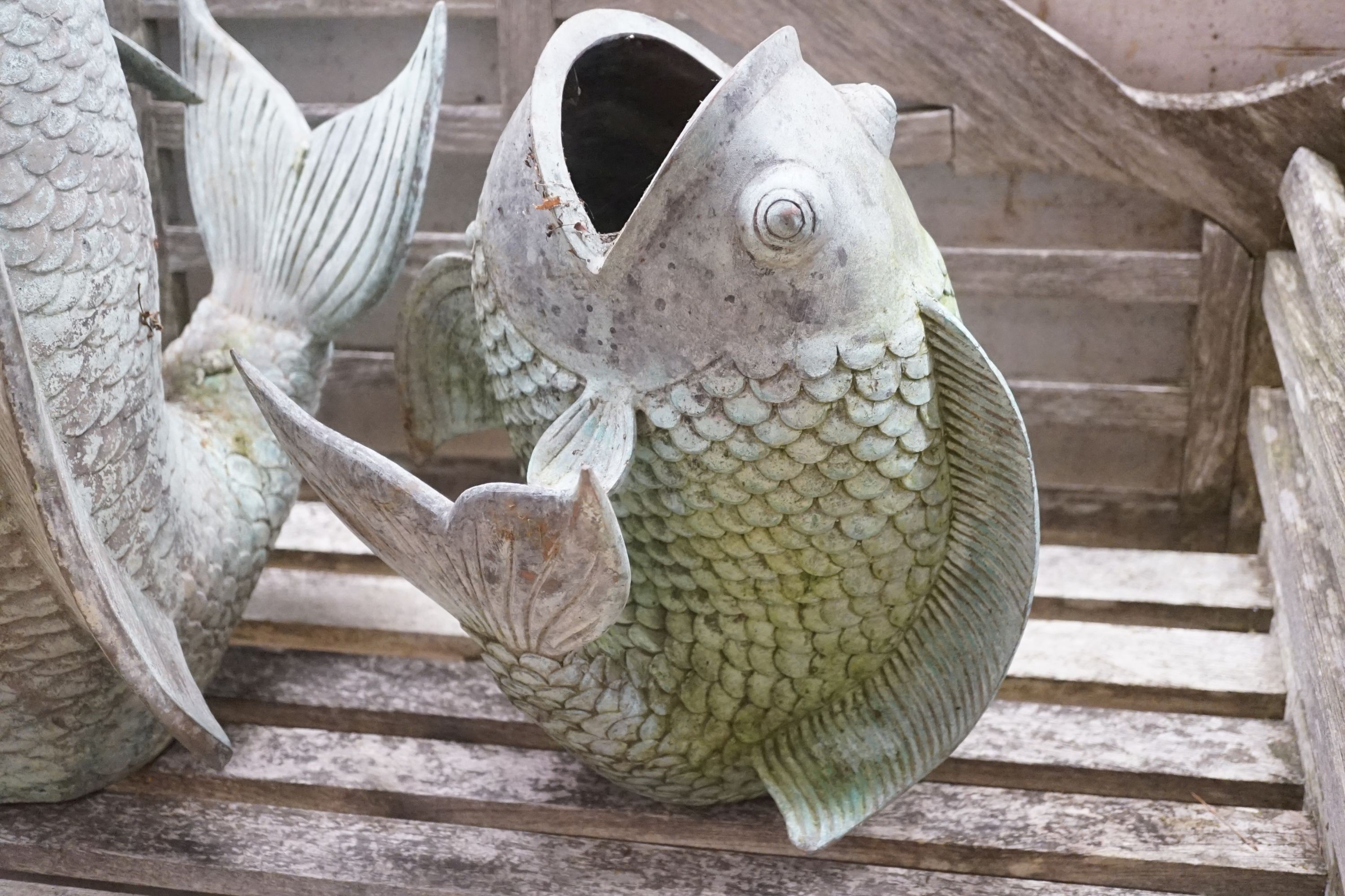 Three cast metal carp garden ornaments, largest 60cm height 46cm